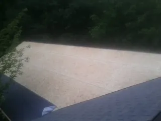 New OSB roof sheathing installed beside an existing shingle roof in Stillwater