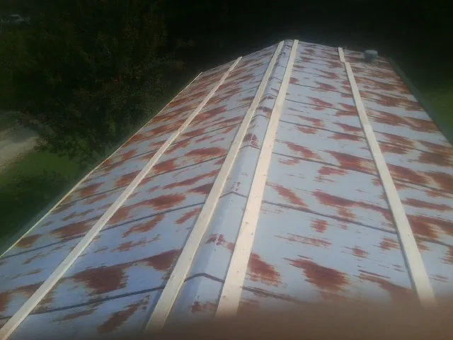 Rusted metal roof panels with new wood purlins before replacement — Storm Damage Roof Repair in Stillwater by Roofing Brothers